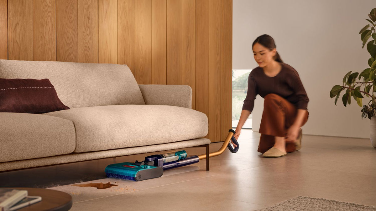 Dyson Clean+Wash Hygiene washing the floor under a sofa